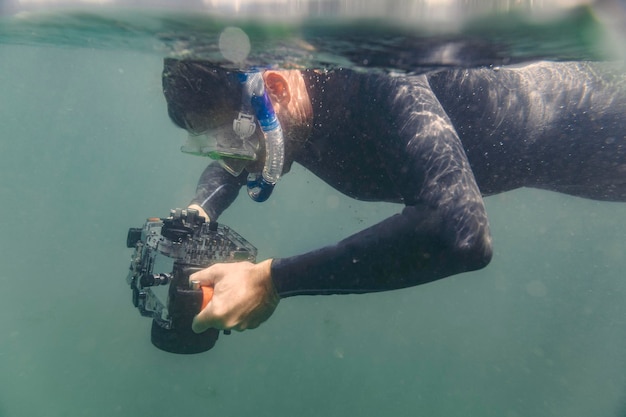 Man diving with underwater DSLR camera case