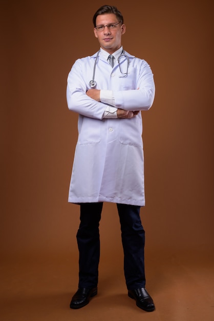 Man doctor against brown wall