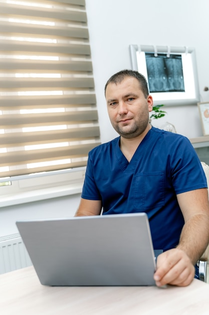 Man doctor looking to the camera. Terapist giving online consultation to the client. Pandemic restrictions.