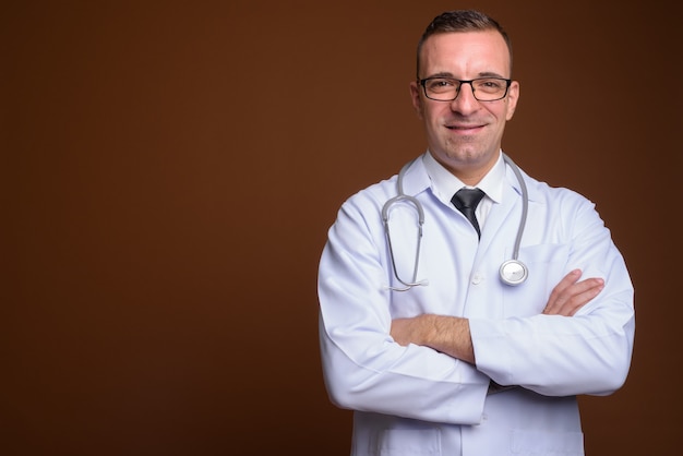 Man doctor wearing eyeglasses on brown