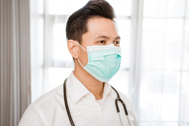 Man doctor wearing medical mask standing looking at camera