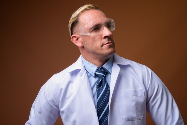 Man doctor wearing protective glasses while thinking