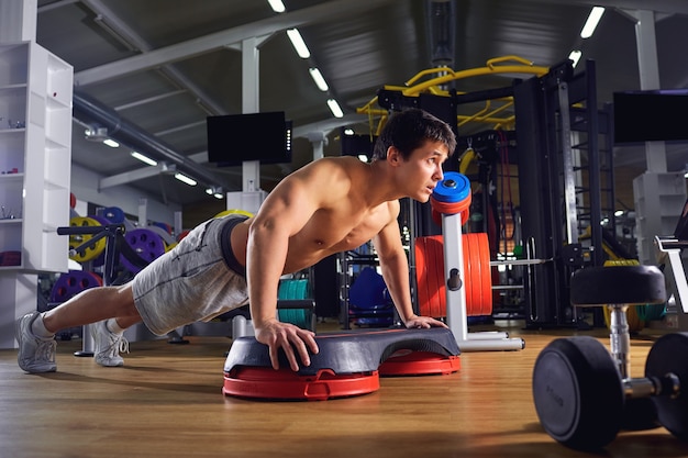 Foto un uomo fa flessioni dal pavimento in palestra