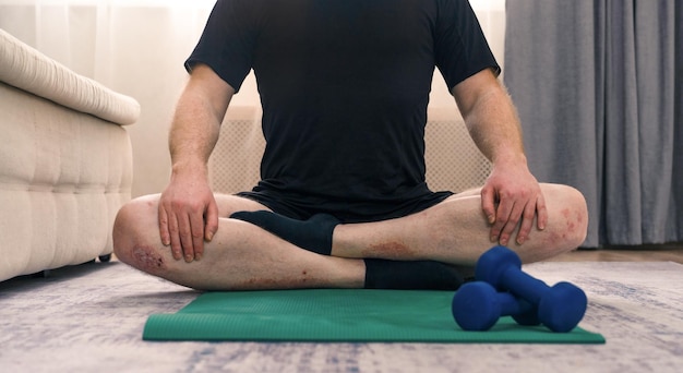 A man does sports on a gym mat