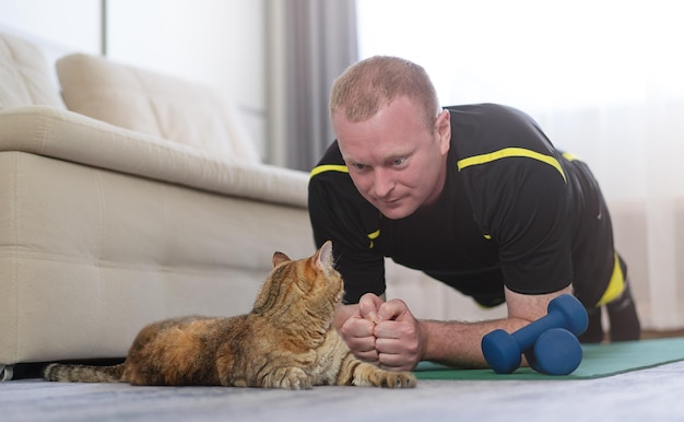 A man does sports at home on the carpet