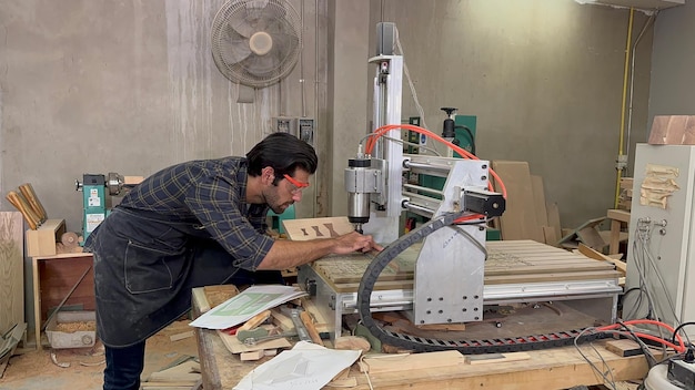 Man doet houtbewerking in timmerwerk Timmerman werkt aan houten plank in werkplaats