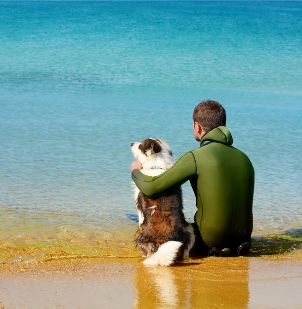 Photo man and dog on sea