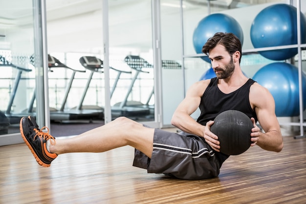 Man doing exercise with medicine ball in the studio