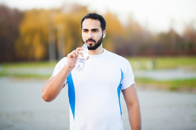 Uomo che fa fitness all'aperto ascoltando musica