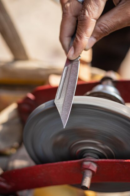 Photo man doing knife sharpen at iron sharpener from different angle