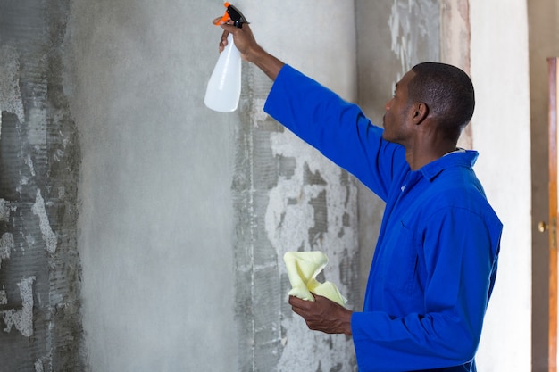 Man doing pest control on a wall