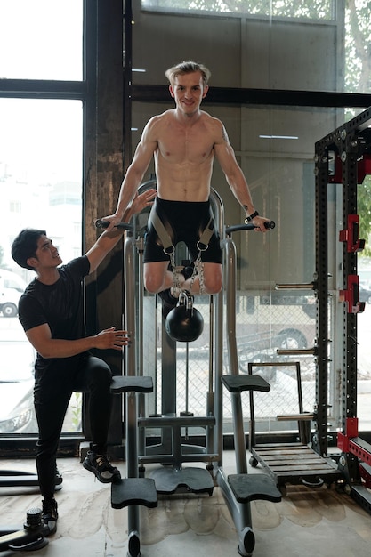 Photo man doing pullups with weight