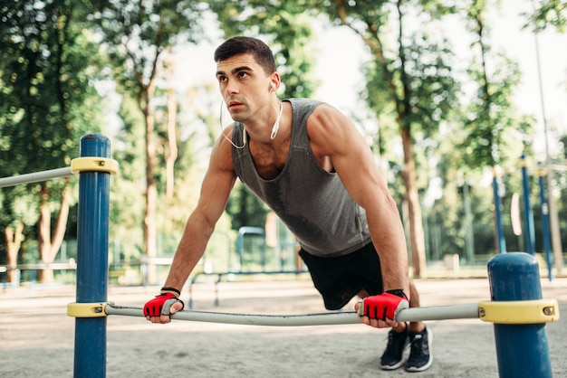 Man doing push-up exercise using horizontal bar