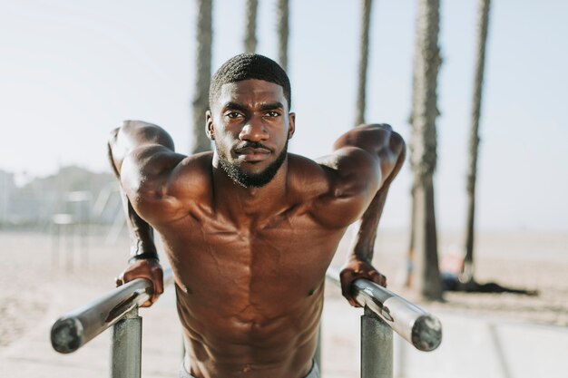 Photo man doing push ups on bars