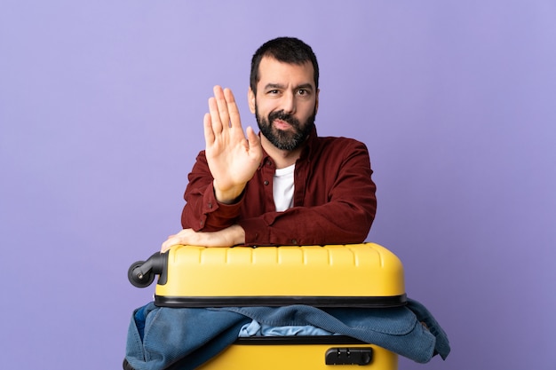 Man doing suitcase over isolated wall