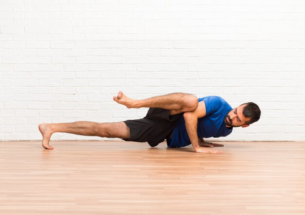 Man doing yoga exercises indoors