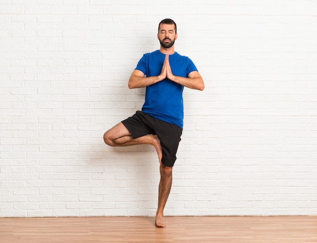 Photo man doing yoga exercises indoors