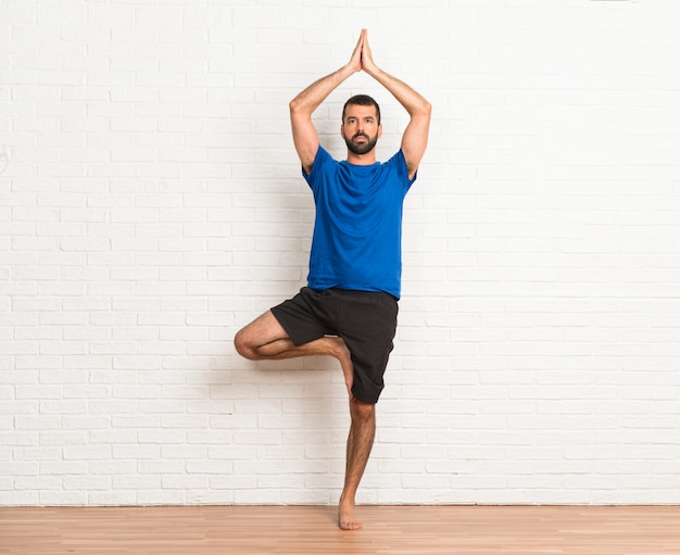 Photo man doing yoga exercises indoors