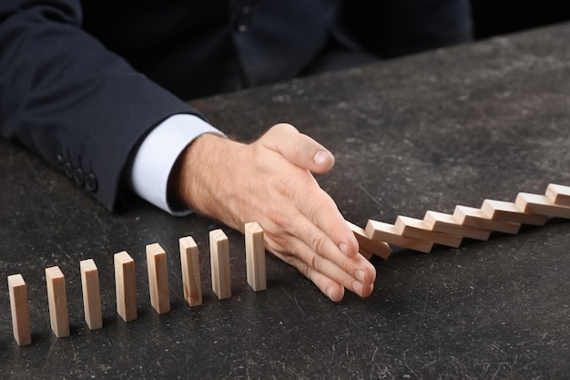 Man and domino pieces on table Management concept