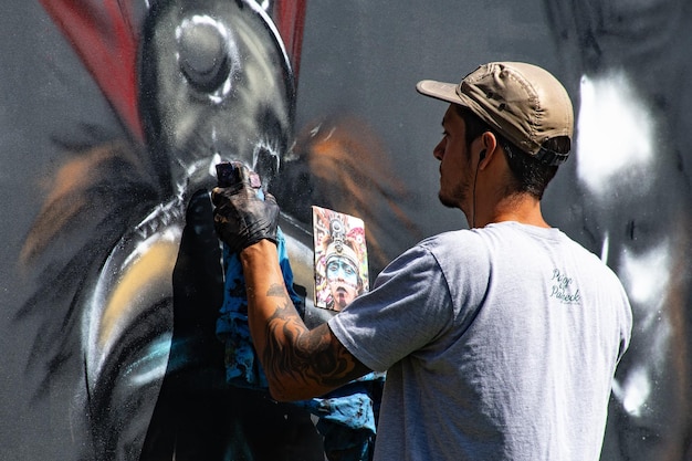 Foto man draagt grijs crewneck shirt schilderij op de muur foto