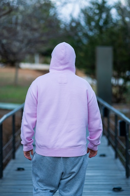 Foto man draagt roze en grijze sportkleding loopt bijna 's nachts over een brug