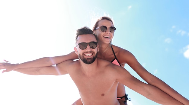 Man draagt vrouw mee op het strand