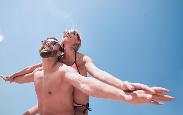 Man draagt vrouw mee op het strand