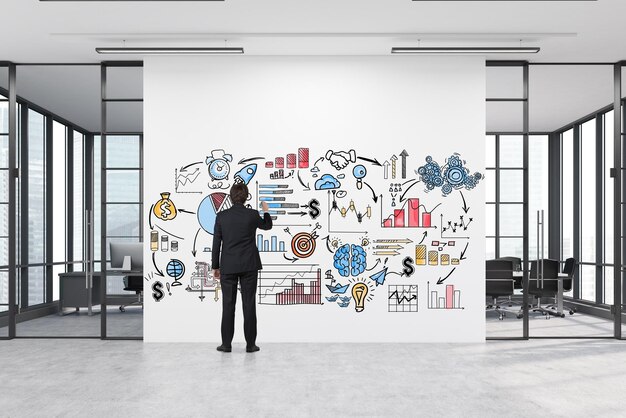 Man drawing a business poster in a corridor with two meeting rooms