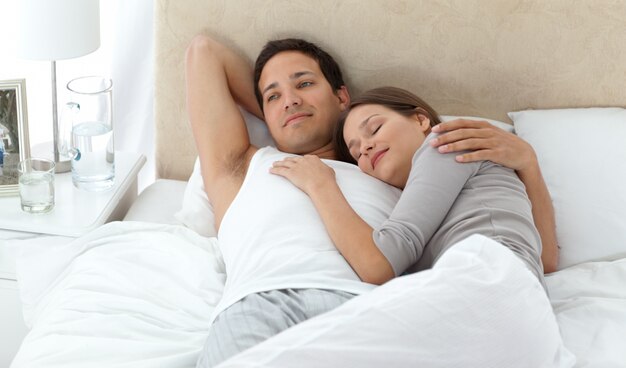 Man dreaming on his bed while relaxing with his girlfriend 