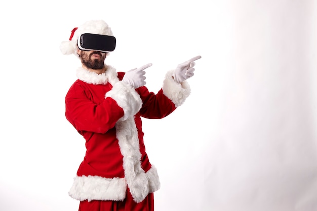 Man dressed as Santa Claus with virtual reality goggles on a white background