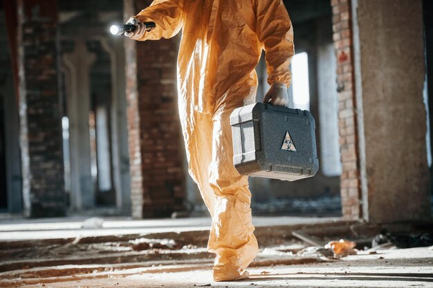 Man dressed in chemical protection suit in the ruins of the post apocalyptic building