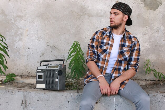 A man dressed in hip hop style poses on camera