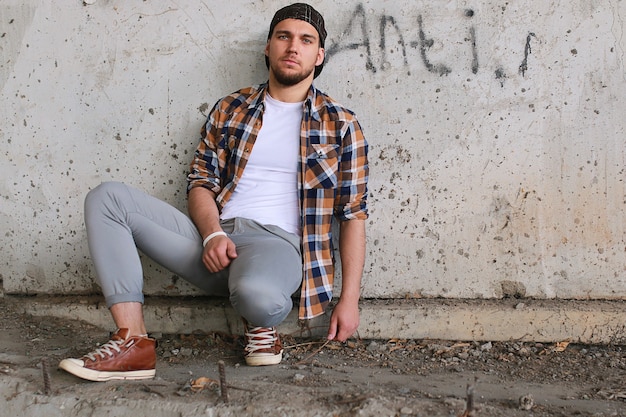 A man dressed in hip hop style poses on camera