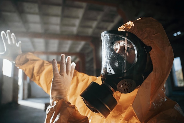写真 黙示録的な建物の廃墟で化学防護服を着た男性