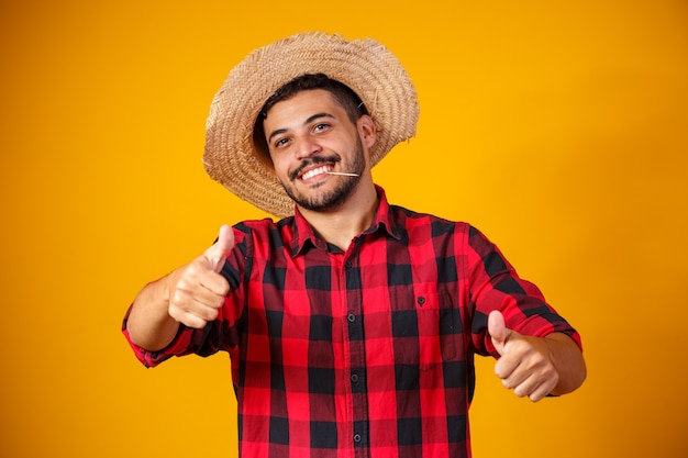 Uomo vestito in abito da festa junina con il pollice in alto facendo segno ok