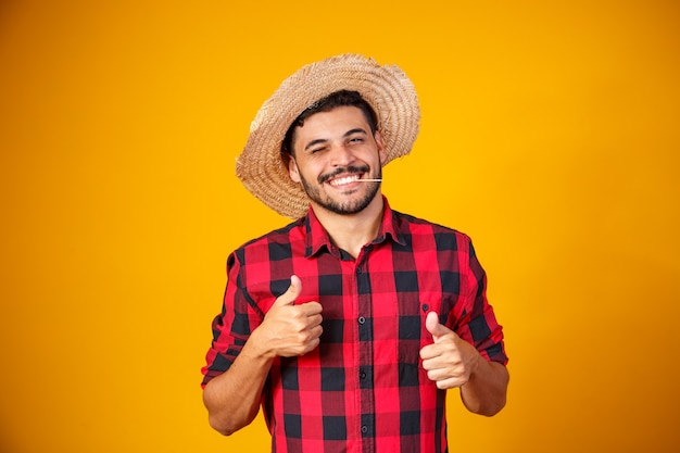 Man dressed in junina party outfit with thumb up making ok sign