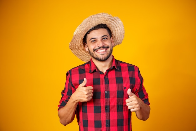 Uomo vestito in abito da festa junina con il pollice in alto facendo segno ok