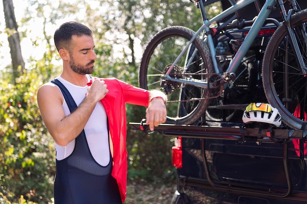 Man dressing next to his van to go cycling