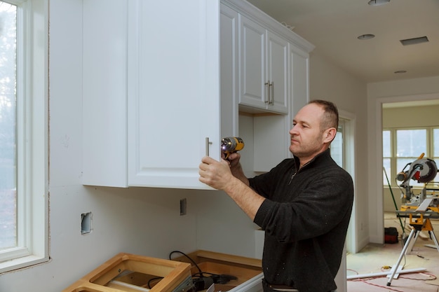 Photo man drilling cabinet at home