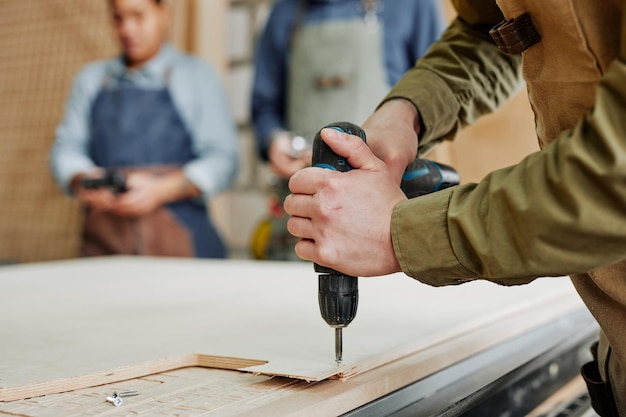 Photo man drilling wood closeup