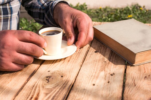 man drink een koffie in de tuin