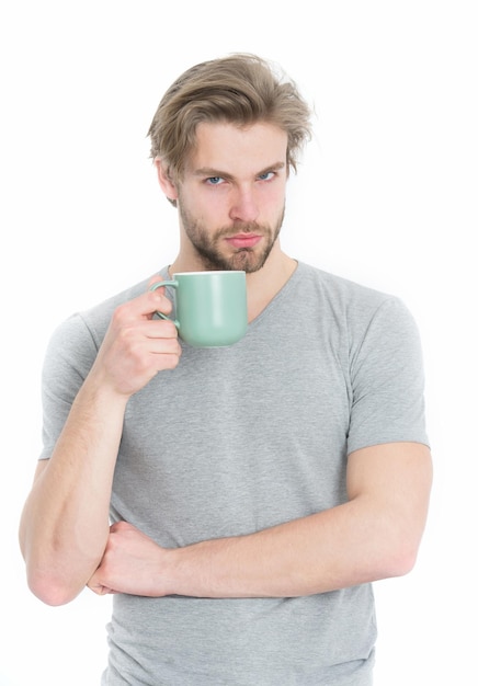 男は白い背景で隔離のコーヒーやティーカップから飲む