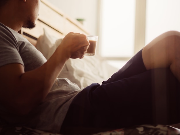 Man drink hot coffee and relax in his room.