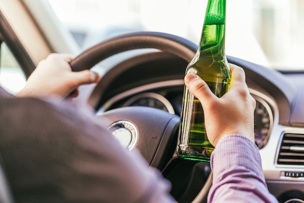 Uomo che beve alcolici mentre guida l'auto