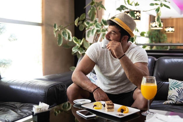 Man Drinking Coffee in a Hotel Lobby Bar