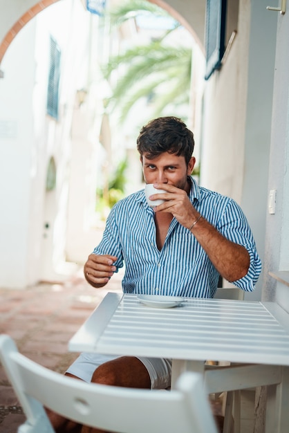 Uomo che beve caffè in un caffè di strada