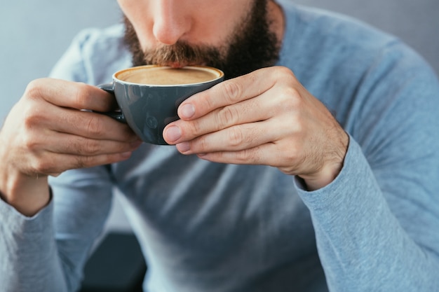 Uomo che beve caffè. bevanda energizzante calda tradizionale