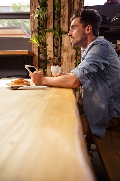 Uomo che beve caffè e facendo uso della compressa