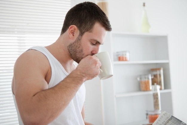 ニュースを読んでいる間にコーヒーを飲む男