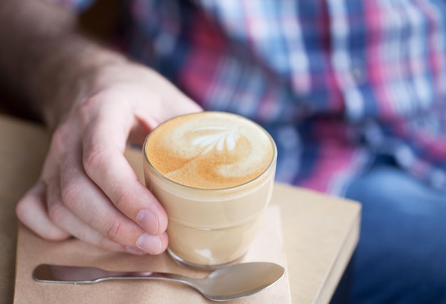 おいしいカプチーノを飲む男